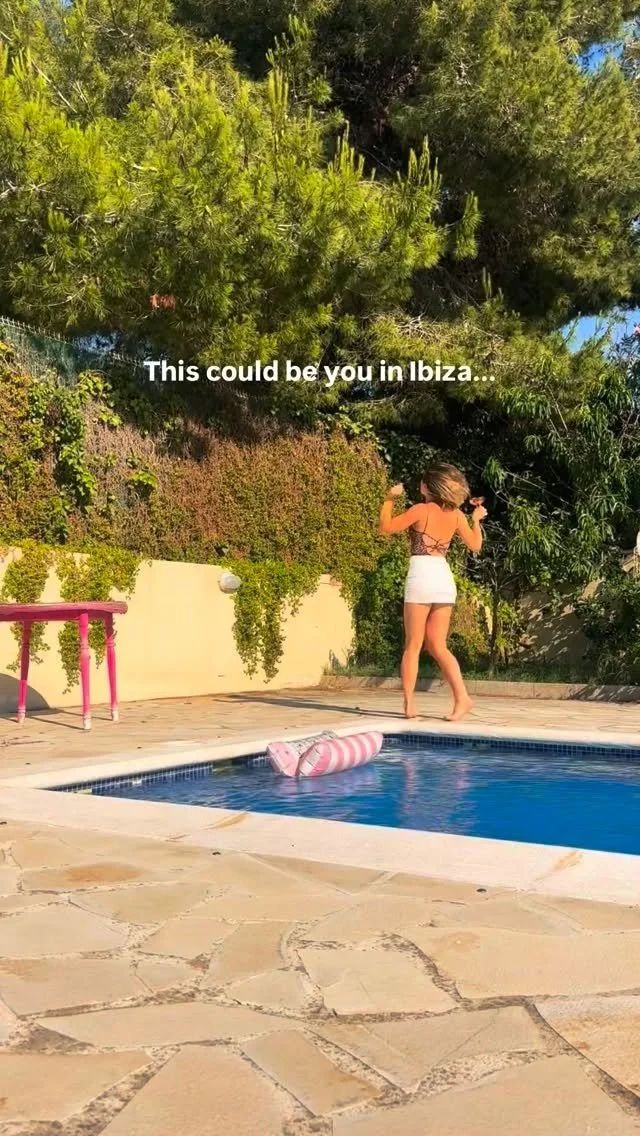 A woman walking beside a villa pool among pine trees, with the caption This could be you in Ibiza